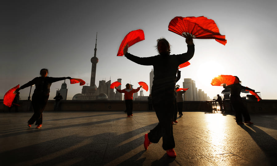 Gente bailando en China, usando los accesorios típico de la región